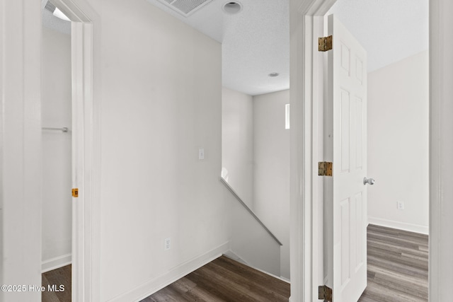stairway featuring visible vents, baseboards, and wood finished floors