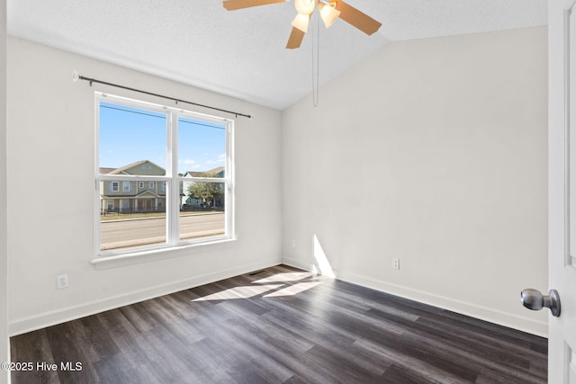 spare room featuring dark wood finished floors, ceiling fan, lofted ceiling, and baseboards