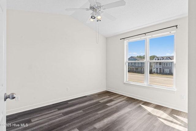 spare room with lofted ceiling, baseboards, dark wood-type flooring, and ceiling fan