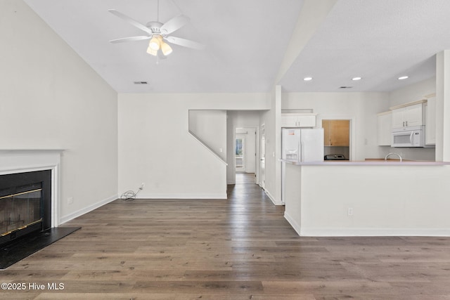 unfurnished living room featuring recessed lighting, wood finished floors, a ceiling fan, baseboards, and a glass covered fireplace
