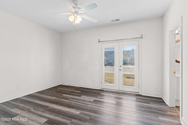 unfurnished room with visible vents, dark wood-style floors, ceiling fan, and french doors