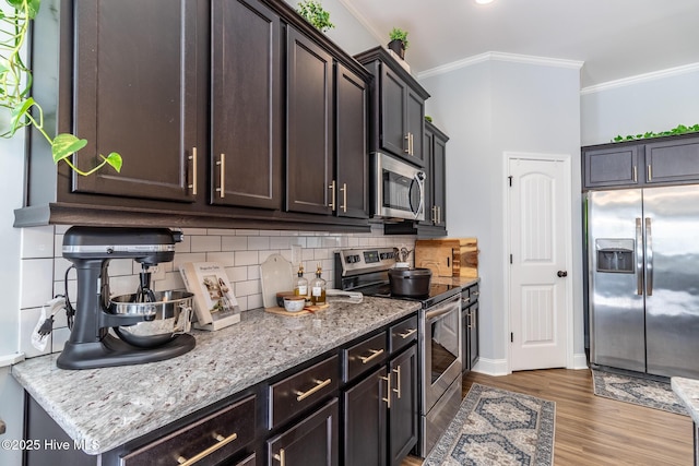 kitchen with appliances with stainless steel finishes, dark brown cabinetry, crown molding, and backsplash