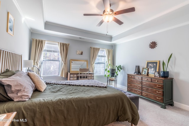 bedroom with ceiling fan, a tray ceiling, carpet flooring, and ornamental molding