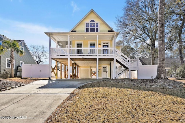 raised beach house featuring covered porch, a garage, and a carport