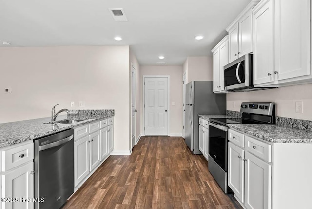 kitchen with visible vents, appliances with stainless steel finishes, light stone countertops, white cabinetry, and a sink