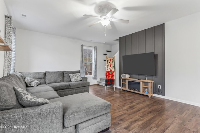 living room with visible vents, dark wood-style flooring, a ceiling fan, and baseboards