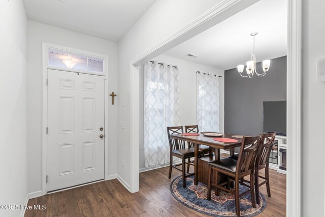 dining area featuring dark wood-style floors, baseboards, visible vents, and an inviting chandelier