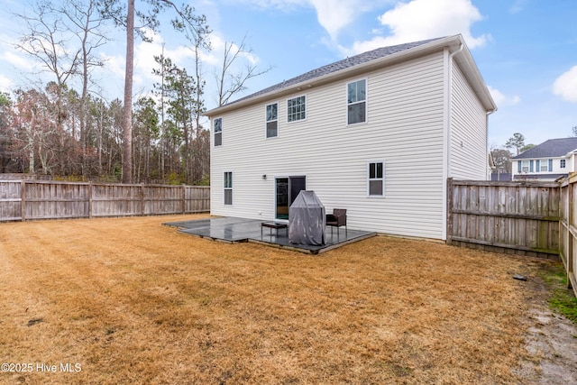 rear view of house featuring a patio area, a lawn, and a fenced backyard