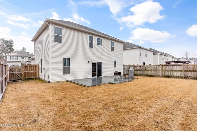 back of property featuring a fenced backyard, a lawn, and a patio