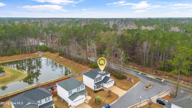 drone / aerial view featuring a water view and a view of trees