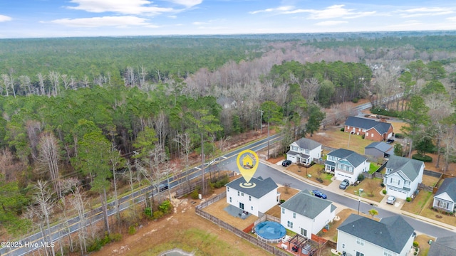 drone / aerial view with a wooded view and a residential view