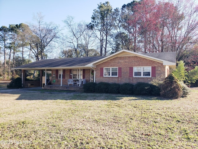 ranch-style house featuring a porch, an attached carport, a front yard, and brick siding