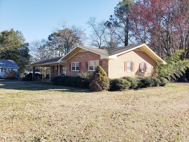 view of property exterior with a carport, brick siding, and a lawn