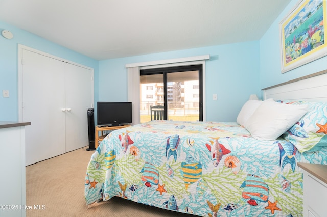 bedroom featuring a closet, access to outside, and light colored carpet