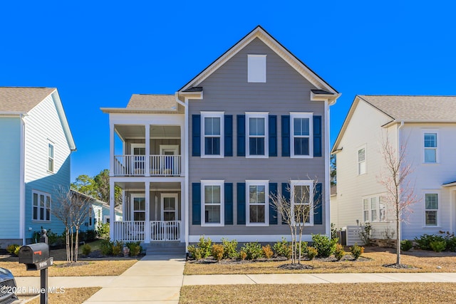 view of property with covered porch, ac unit, and a balcony