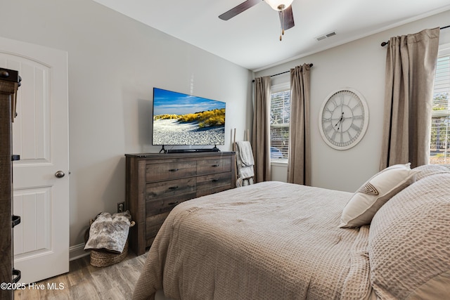 bedroom with visible vents, ceiling fan, baseboards, and wood finished floors