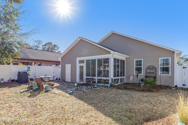 rear view of property with a sunroom and fence