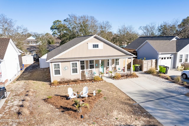 view of front of property featuring covered porch, fence, and driveway