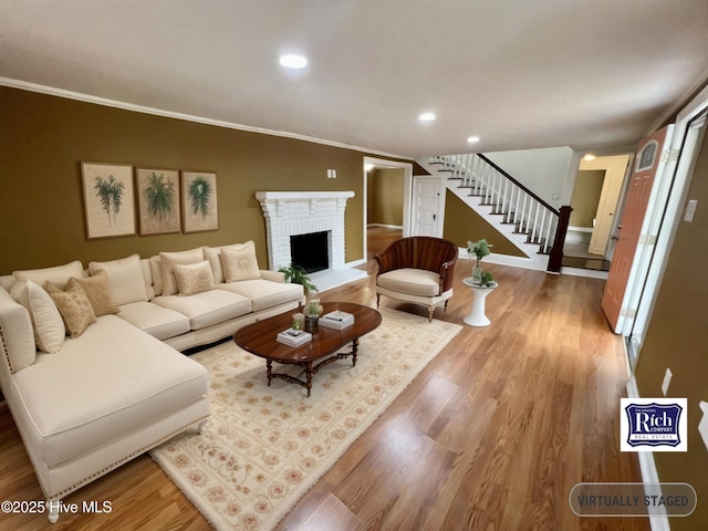 1206 N Bonner St, Washington, NC 27889 - living room featuring crown molding, stairway, wood finished floors, a brick fireplace, and recessed lighting