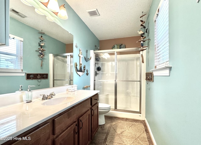 full bathroom featuring a textured ceiling, toilet, a shower stall, and visible vents