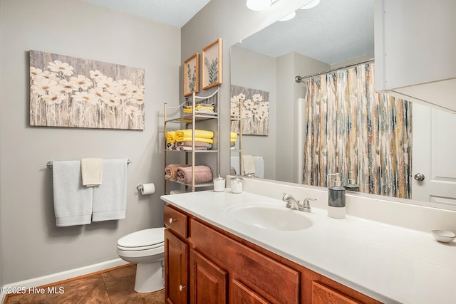 bathroom featuring toilet, tile patterned flooring, baseboards, and vanity