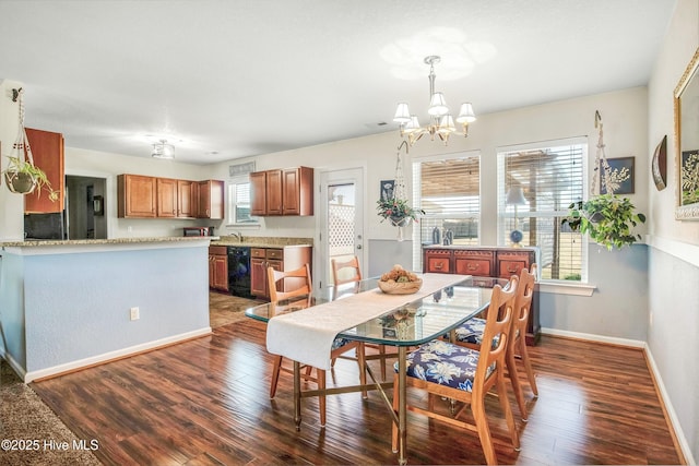 dining room with a chandelier, dark wood finished floors, and baseboards