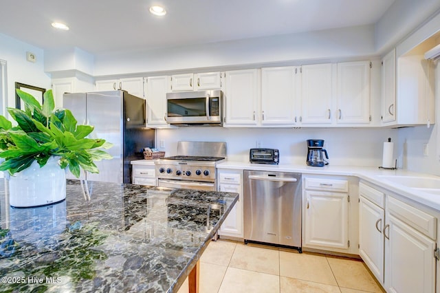 kitchen featuring recessed lighting, appliances with stainless steel finishes, white cabinets, a sink, and light tile patterned flooring