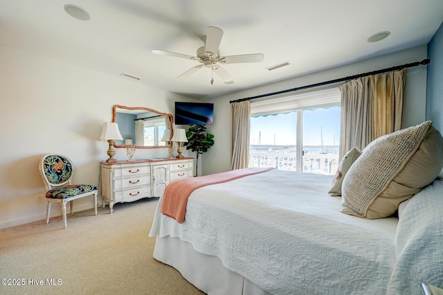 bedroom with a ceiling fan, visible vents, light carpet, and multiple windows