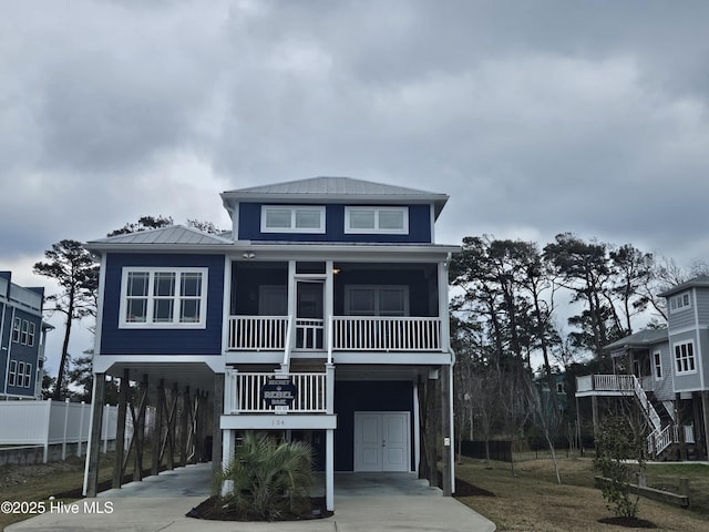 beach home featuring metal roof, a carport, and concrete driveway