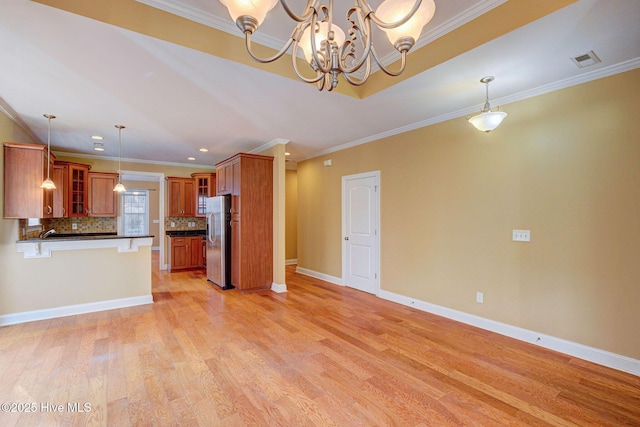 kitchen with stainless steel fridge, visible vents, brown cabinetry, light wood-style flooring, and glass insert cabinets