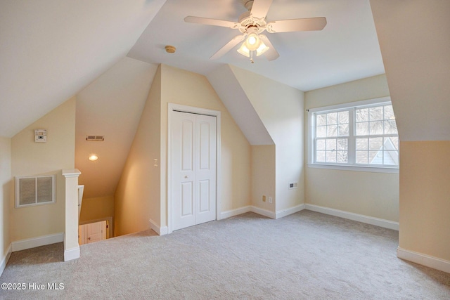 additional living space featuring carpet floors, lofted ceiling, visible vents, a ceiling fan, and baseboards