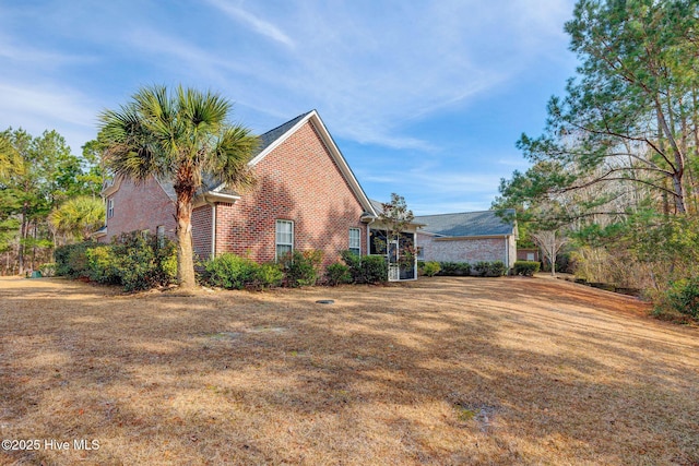 view of property exterior with a lawn and brick siding