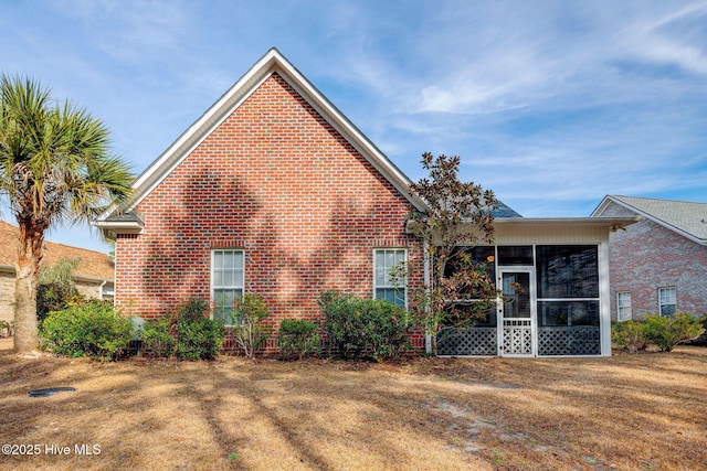 exterior space with a sunroom and brick siding