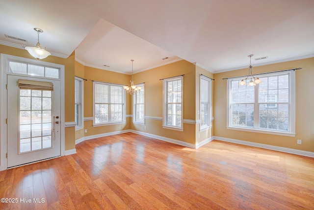 foyer featuring crown molding, light wood-style floors, visible vents, and an inviting chandelier