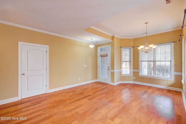 empty room featuring ornamental molding, baseboards, and light wood finished floors