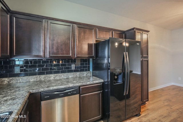 kitchen with dark brown cabinets, decorative backsplash, stainless steel dishwasher, light wood-style flooring, and black fridge with ice dispenser