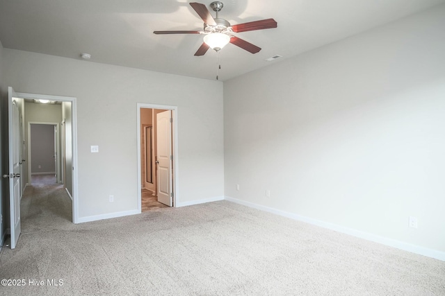 unfurnished bedroom featuring baseboards, visible vents, a ceiling fan, light carpet, and ensuite bath