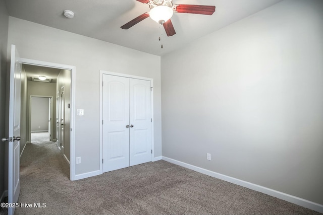 unfurnished bedroom with ceiling fan, carpet floors, a closet, and baseboards