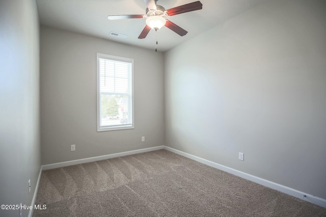 spare room with ceiling fan, carpet floors, visible vents, and baseboards