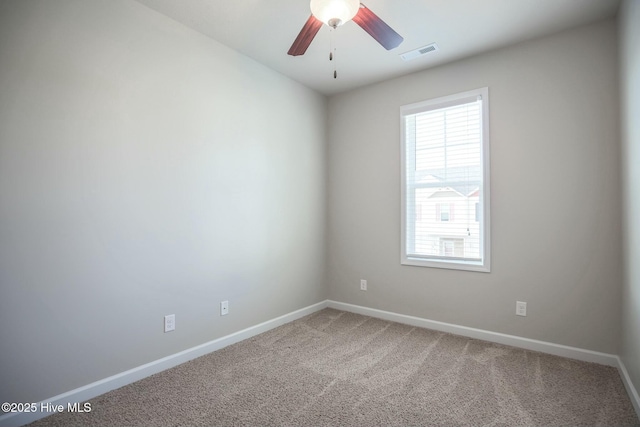 empty room featuring a ceiling fan, visible vents, carpet floors, and baseboards