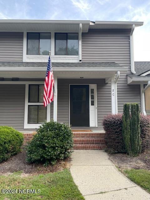 entrance to property featuring brick siding and a porch