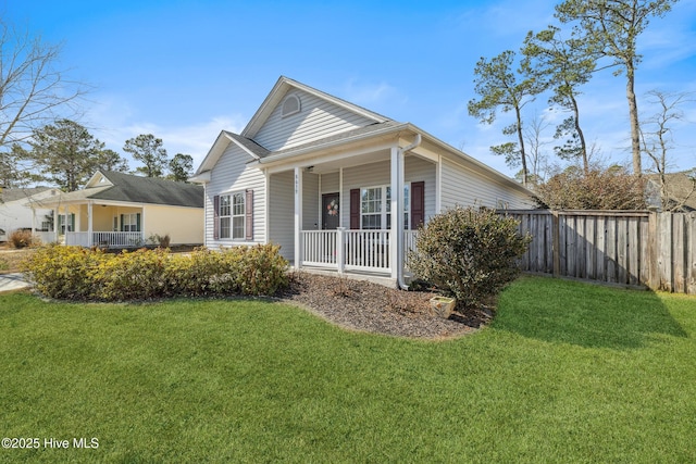 exterior space featuring covered porch, a yard, and fence