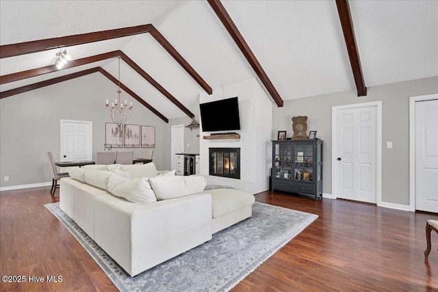 living room featuring a notable chandelier, dark wood-type flooring, baseboards, a brick fireplace, and beamed ceiling