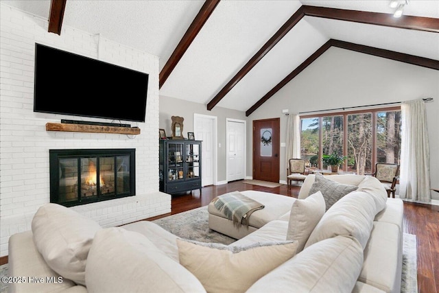 living area with baseboards, dark wood-style flooring, beamed ceiling, a fireplace, and high vaulted ceiling