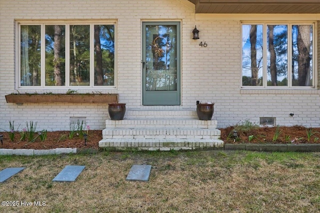 entrance to property with brick siding and crawl space