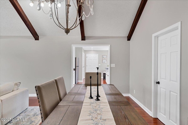 dining area with a chandelier, lofted ceiling with beams, a textured ceiling, and wood finished floors