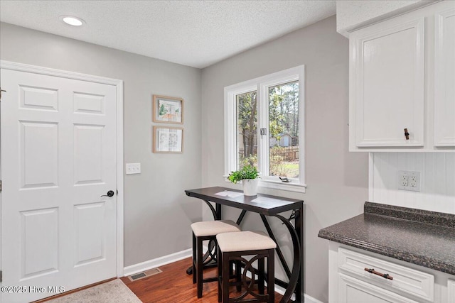 dining room featuring a textured ceiling, recessed lighting, visible vents, baseboards, and dark wood-style floors