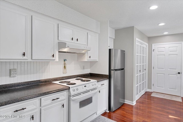 kitchen featuring electric range, dark countertops, freestanding refrigerator, under cabinet range hood, and white cabinetry