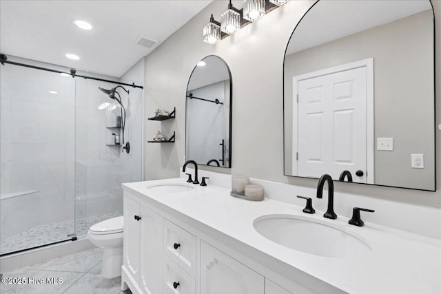 full bathroom with toilet, double vanity, visible vents, and a sink