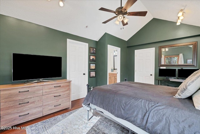 bedroom with dark wood-style floors, lofted ceiling, a ceiling fan, and ensuite bathroom